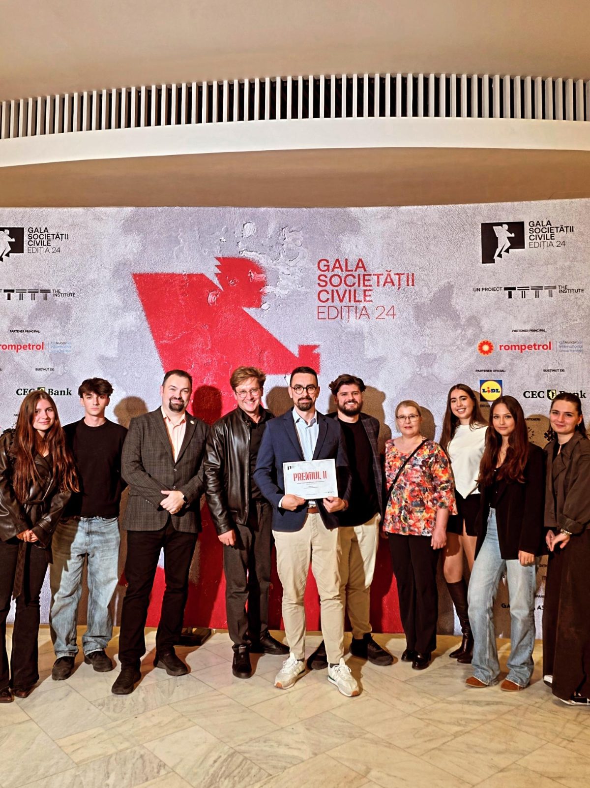 The Susțin team and volunteers in front of the Civil Society Gala backdrop, 24th edition, holding the Second Prize diploma