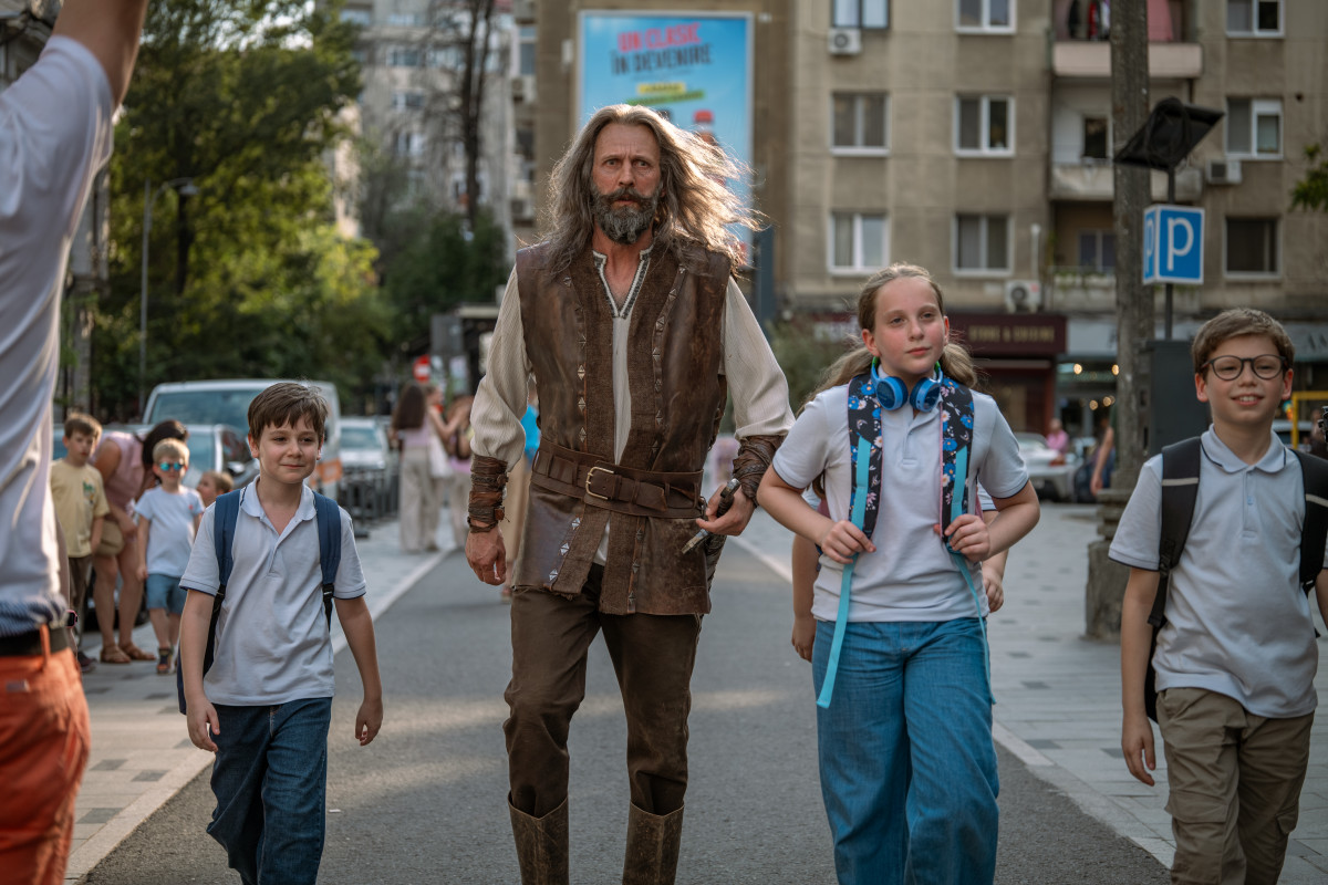 Cadru din Comoara lui Harap-Alb: personajul și copiii merg pe o stradă din București