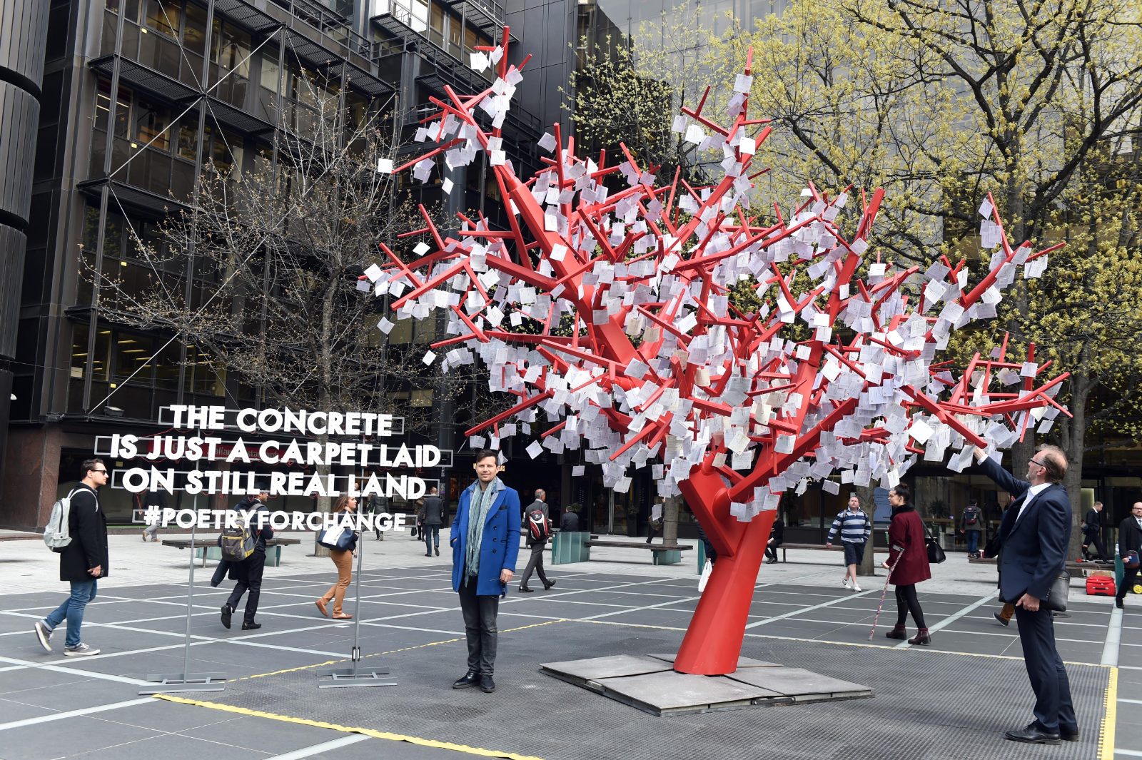 Poet-Tree cu foi albe pe ramurile roșii, lângă poemul luminos, în Finsbury Avenue Square.