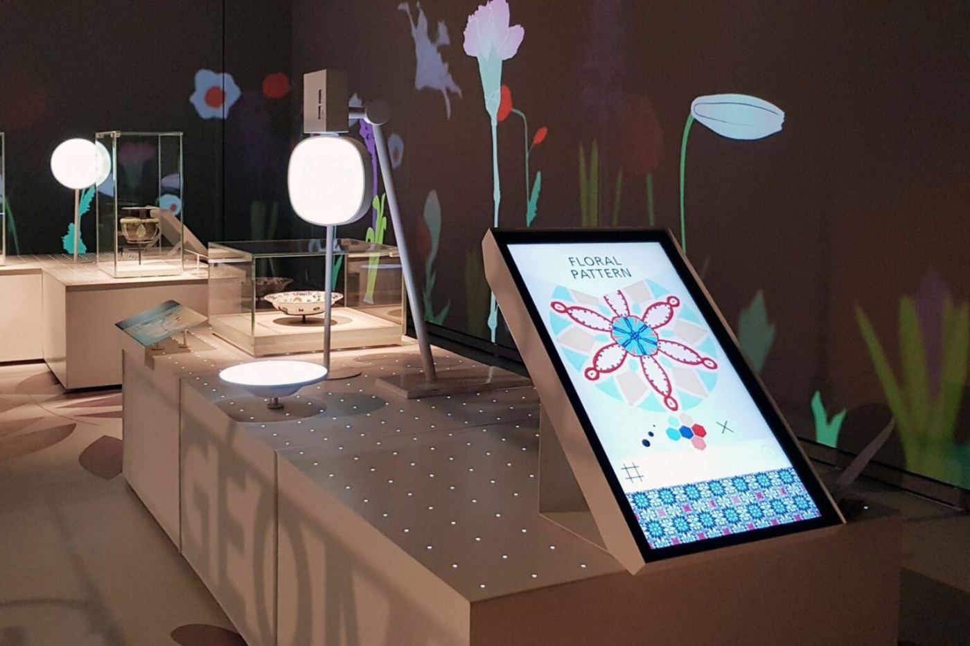 Ecran cu o compoziție florală, alături de vitrinele expoziției