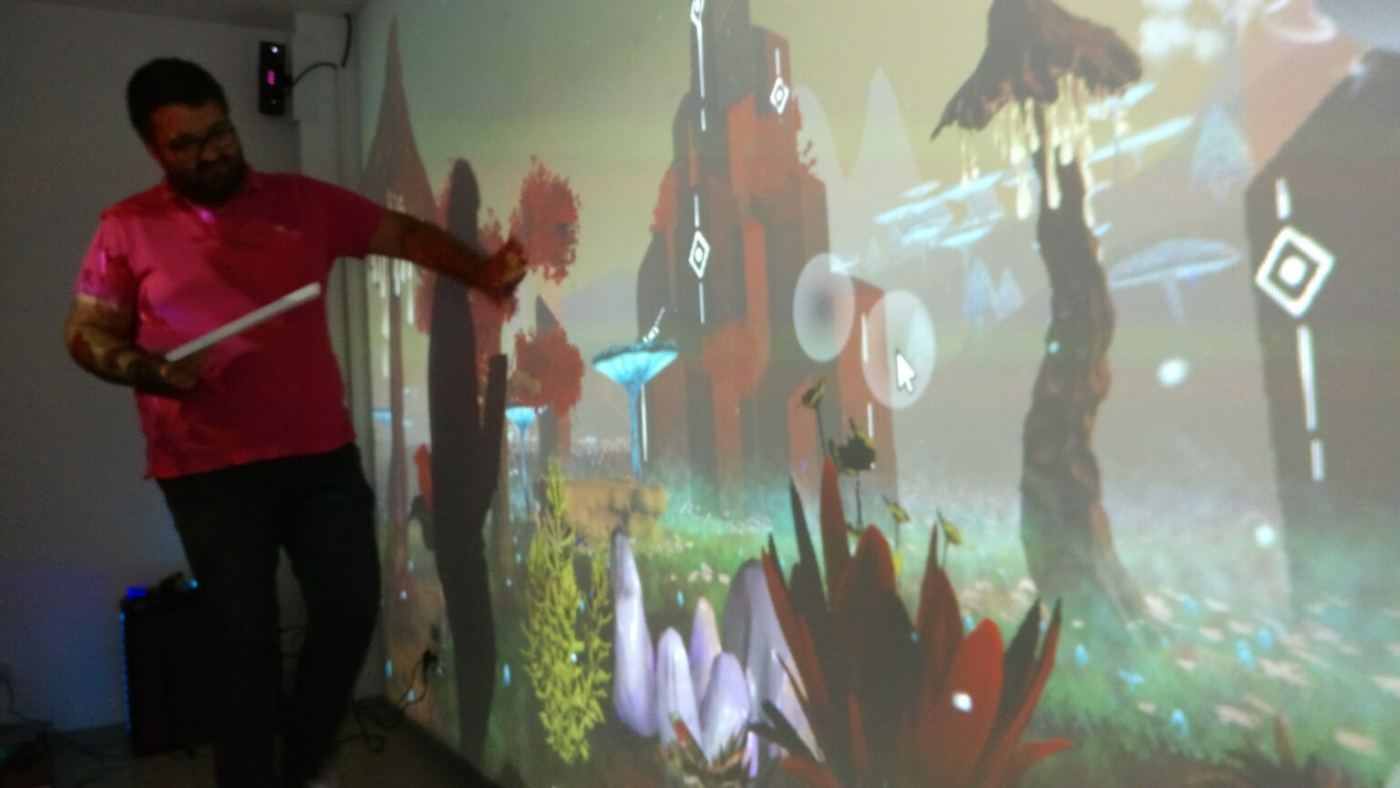 A person touching the wall onto which a scene with characters is projected